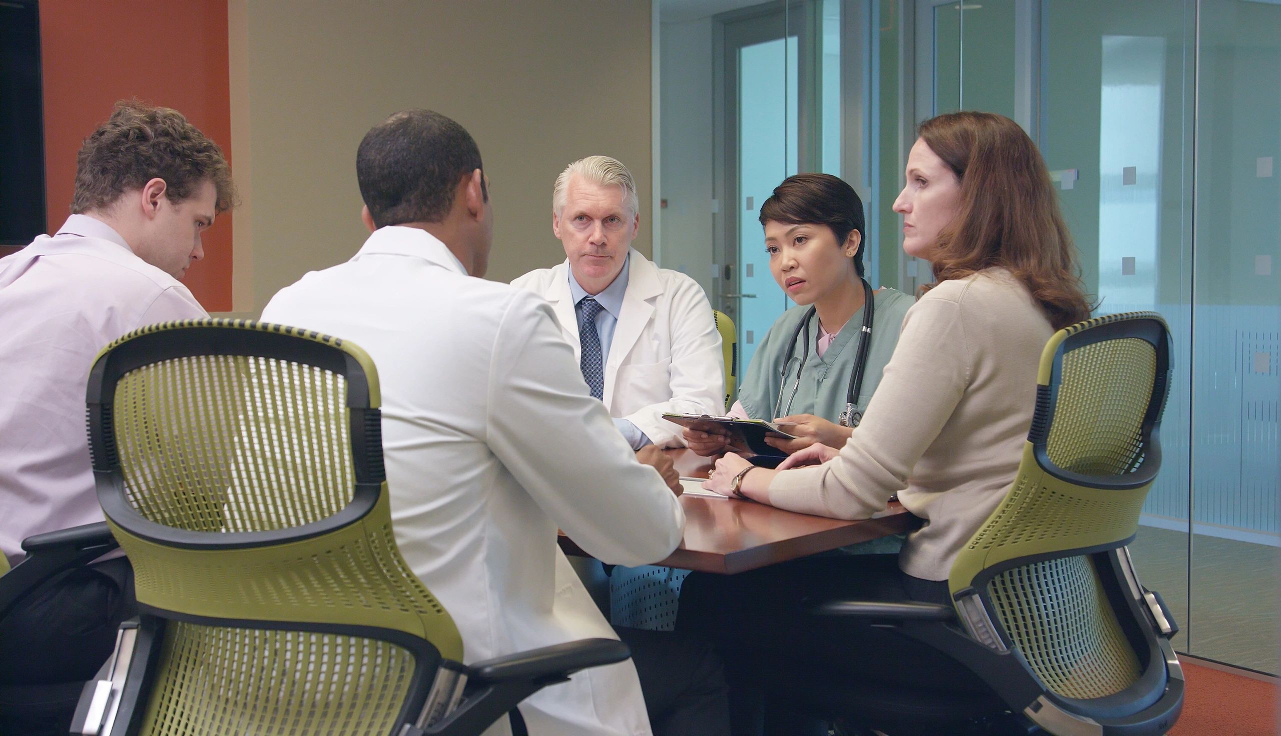 Medical leadership team meeting in a modern office